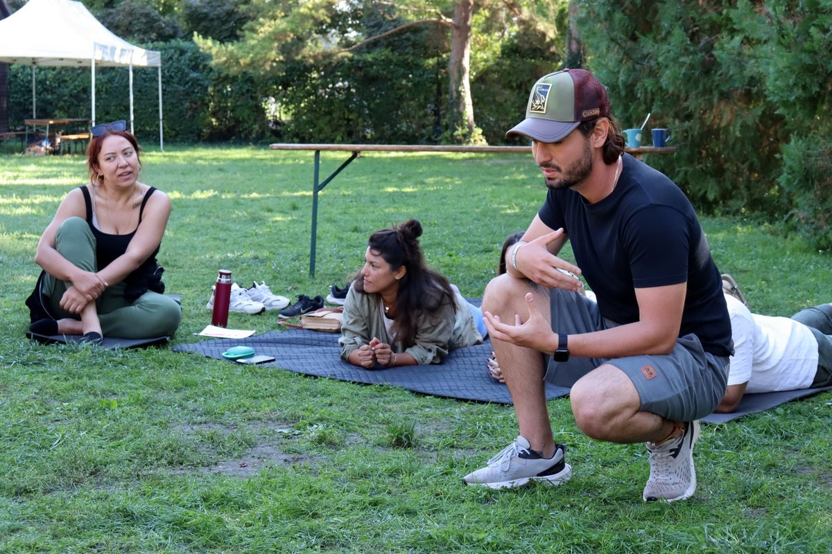Jesús escuchando a dos participantes durante una sesión al aire libre
